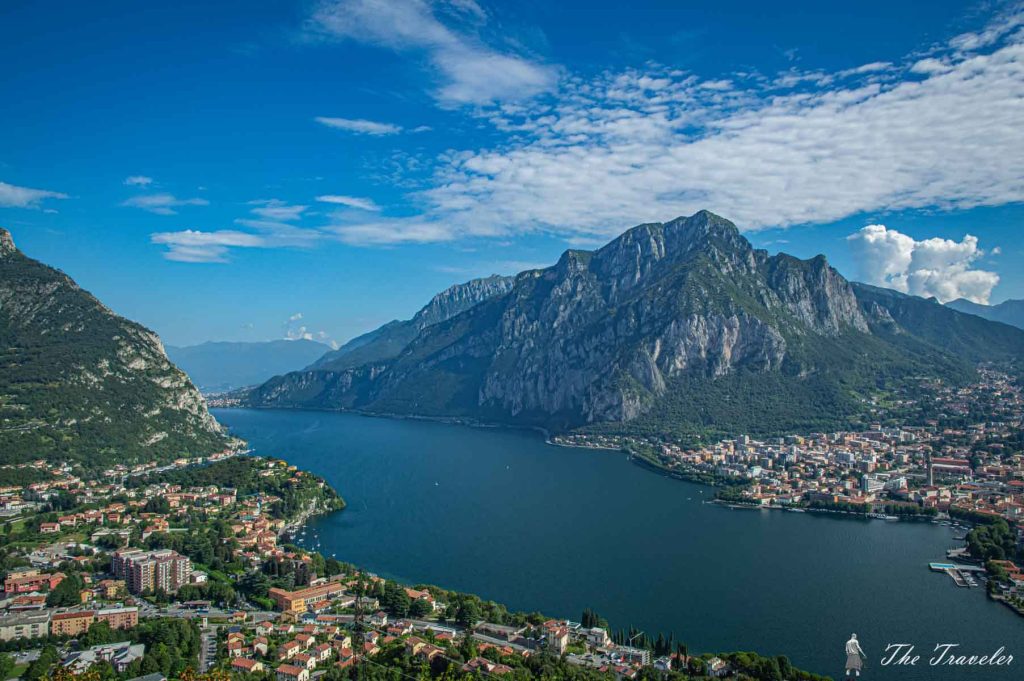 Lake and mountain view with town, perfect for Helipaddy adventures. Vibrant landscape under a clear blue sky.
