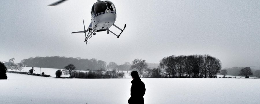 Robinson R44 Helicopter landing in a snowy field