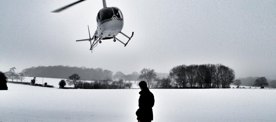 Robinson R44 Helicopter landing in a snowy field