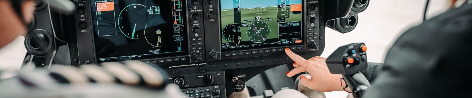 Helicopter cockpit with pilots using advanced controls, showcasing Helipaddy navigation system in flight.
