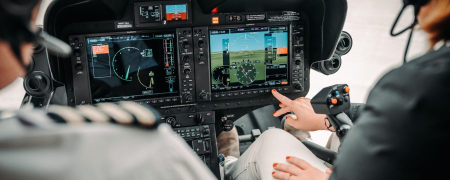 Helicopter cockpit with pilots using advanced controls, showcasing Helipaddy navigation system in flight.