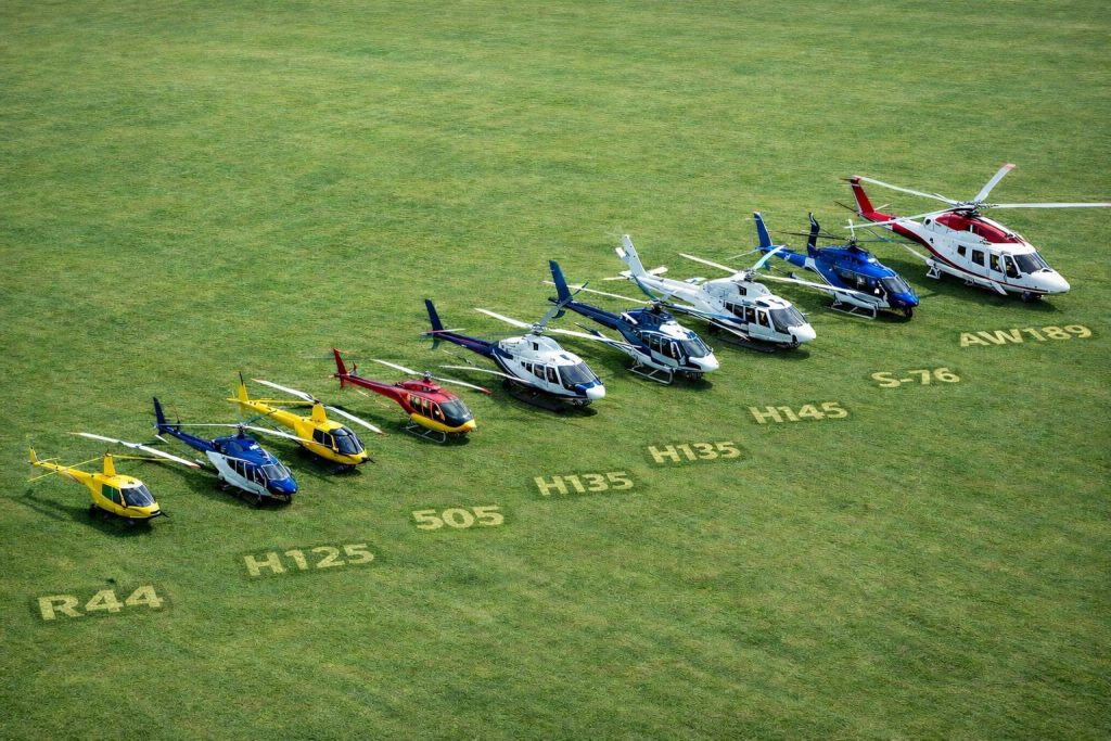 Helicopters lineup on grass with models R44 to AW189, featured on Helipaddy for aviation enthusiasts.