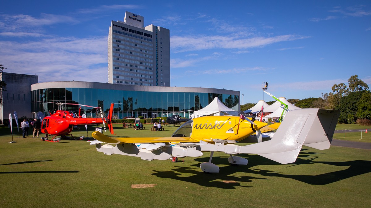 Helipaddy event at Royal Pines Resort featuring helicopters and aircraft on the green lawn under a clear blue sky.