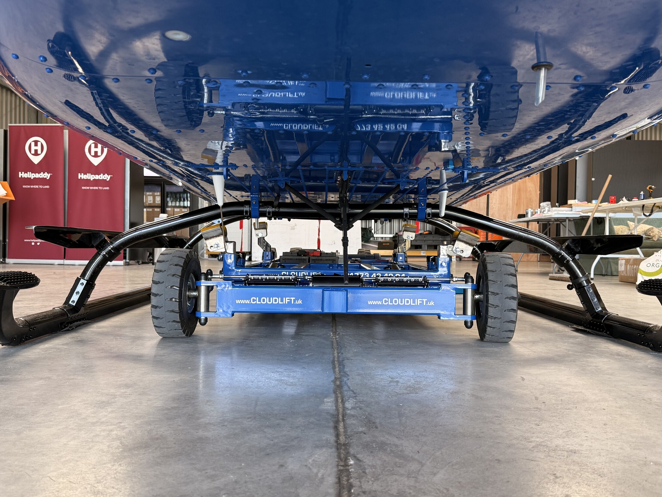 Cloud Lift positioned under the Bell 505 showing the low skid clearance and underside fittings