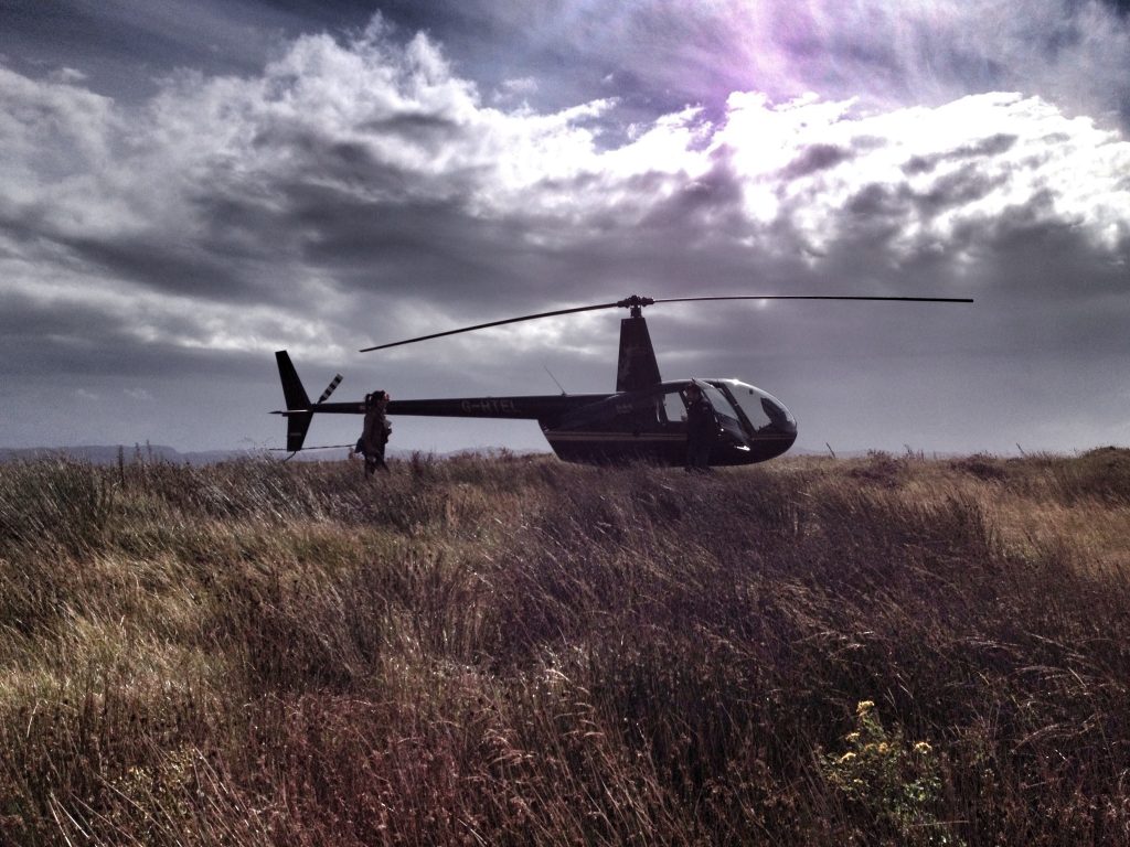 Helicopter landing in rugged West Scotland landscape, perfect for island stops.